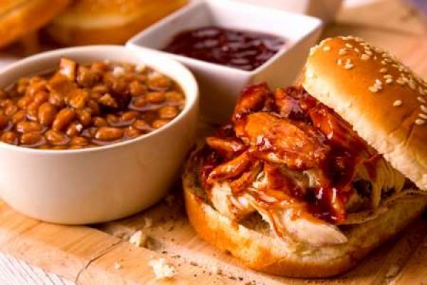 Burger with sides on a wooden cutting board