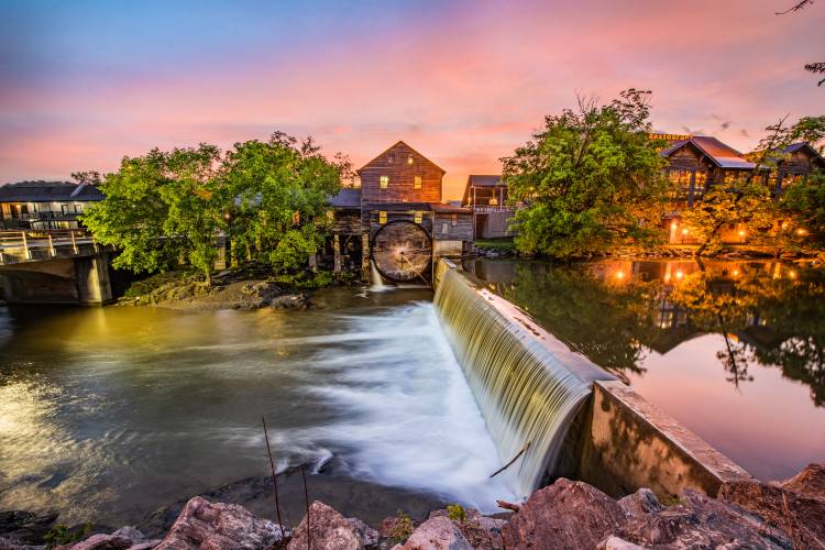 Quiet town with a water mill and small dam during the evening